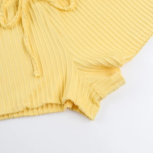 Detailed macro view of yellow ribbed knit fabric texture and matching drawstring on shorts