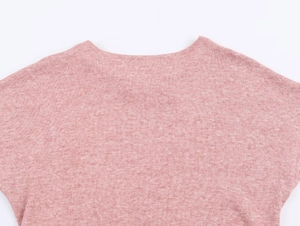 Détail macro de la texture du tricot rose et couture de l'encolure sur le haut