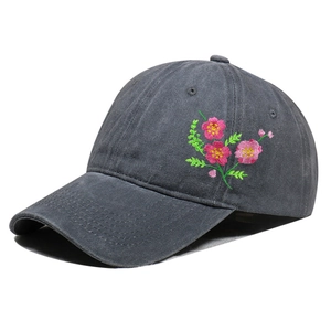 Detail of pink floral embroidery on dark gray washed cotton baseball cap with stitch texture