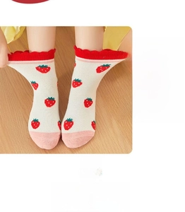 Detail of baby knee-high socks featuring red strawberry patterns and ruffled cuffs