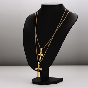 Minimalist double-layered gold stainless steel cross necklace on a black mannequin display