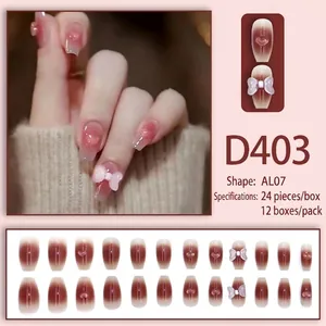 Press-on nails in sheer nude red with 3D heart and bow designs, medium coffin shape