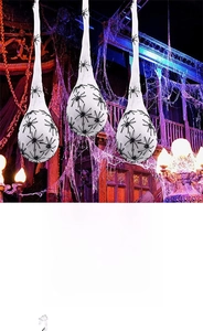 Three glowing Halloween spider egg sacks hanging in a spooky haunted house scene