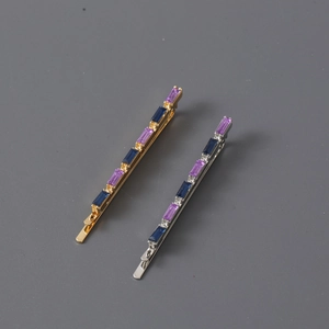 Detailed view of elegant gold and silver hair clips with purple and blue rectangular crystals