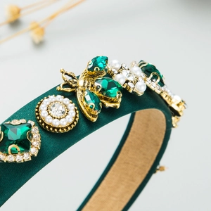 Detail of dark green velvet headband with crystal bee, pearls and emerald gems
