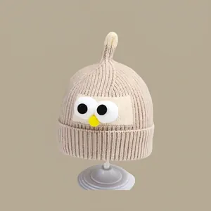 Detail of knit baby beanie with funny cartoon eyes and unique pointed top design
