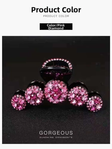 Dettaglio di un fermaglio per capelli in resina nera con strass rosa sfumati