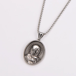 Macro detail of oval pendant with vintage religious relief on silver box chain