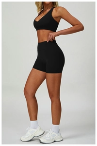 Dettaglio laterale di pantaloncini fitness neri a vita alta e reggiseno sportivo coordinato