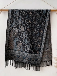 Detail of black cashmere-feel pashmina with blue paisley patterns and fringe tassels