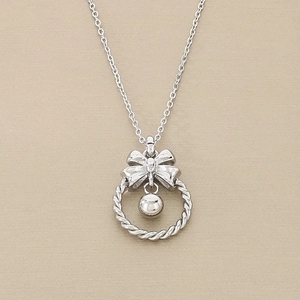 Détail du pendentif nœud argenté avec clochette ronde sur une chaîne en métal texturé