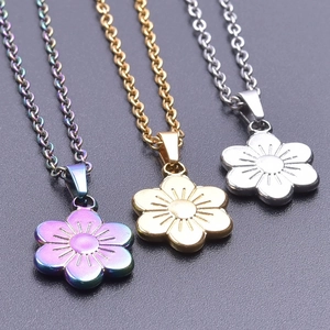 Close-up of minimalist stainless steel flower pendants in gold, silver and rainbow finish