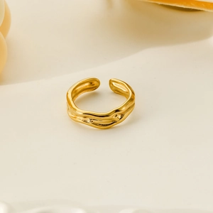 Macro shot of liquid metal gold plated ring with irregular organic streamline design