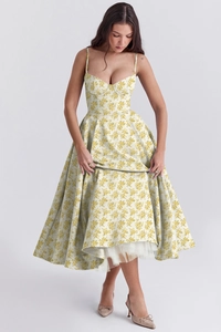 Detail view of yellow floral summer dress showing layered hemline and white mesh lining