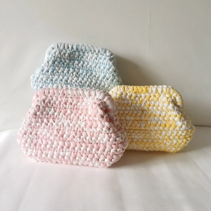 Detail showing handmade crochet cloud bags in pink, yellow and blue woven cotton cord