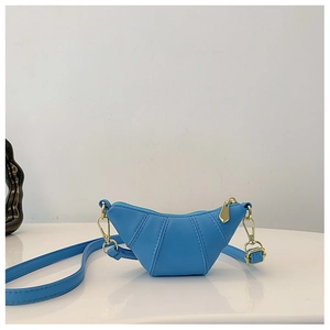 Close-up of blue mini crescent horn bag with golden zipper and metal chain strap detail