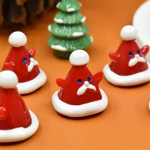 Vue détaillée de cinq bonnets de Père Noël miniatures en résine sur fond de fête