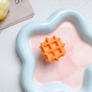 Dettaglio macro di un supporto per cellulare a waffle arancione su un piatto di ceramica