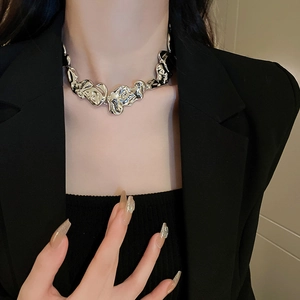 Detailed view of an irregular hammered lava style silver necklace on a model