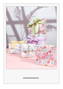 Detail of colorful gift wrapping paper rolls with star, heart, and rainbow patterns and ribbons