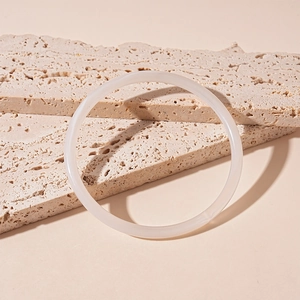 Gros plan d'un bracelet en acrylique blanc translucide dégradé sur pierre naturelle