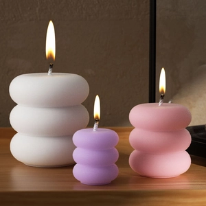 Three-tier stackable ring scented candles in white, lilac, and pink with matte texture