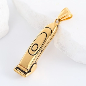 Macro shot of a polished gold barber hair clipper pendant on white textured stone