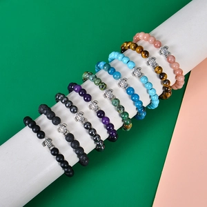 Detailed macro shot of 8mm elastic stone bracelets featuring silver turtle charms on a stand