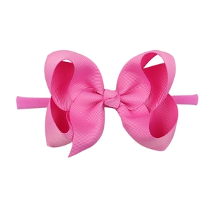 Detail of pink soft ribbon bow on elastic nylon headband for babies and toddlers