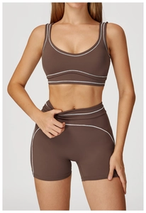 Detail of high-waist yoga shorts with white contrast stitching and brown stretch fabric