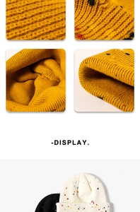 Dettaglio della maglia spessa del berretto giallo con puntini colorati a contrasto
