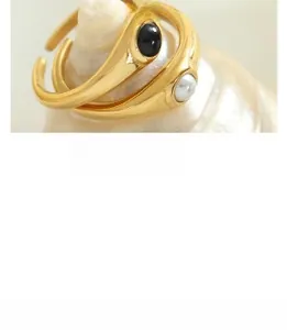 Detailed macro view of two vintage gold dome rings with black gemstone and pearl inlay