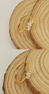 Détails macro d'une bague dorée ajustable avec cinq zircons de taille marquise sertis