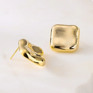 Irregular gold-plated geometric square stud earrings in 925 silver on marble surface