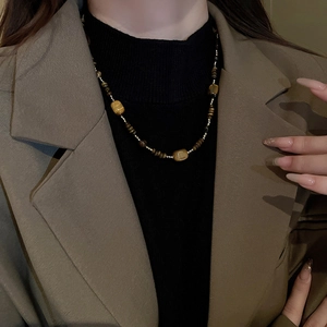 Collier rétro perlé en œil de tigre avec cubes marrons sur un mannequin femme