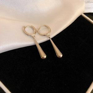 Macro shot of silver-colored teardrop earrings on a black velvet jewelry box