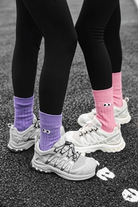 Detail of candy-colored crew socks with cartoon eye embroidery in purple and pink