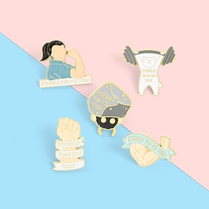 Detail of five enamel pins set with fitness motifs and stronger than you think text