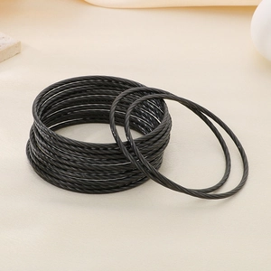 Macro detail of black twisted rope bracelets showing layered metallic spiral textures