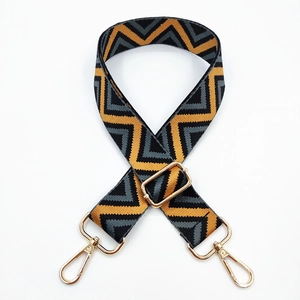 Close-up of retro chevron pattern woven bag strap with golden metal swivel hooks