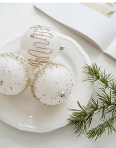 Champagne and silver Christmas baubles with sequins and beads on a ceramic tray decoration