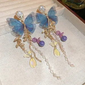 Blue mesh butterfly tassel earrings with pearls and crystal droplets in a jewelry box