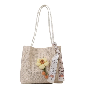 Beige woven bucket tote bag with yellow fabric flowers and a patterned silk scarf
