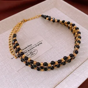 Vintage double-layer black beaded necklace with gold metal accents in a jewelry box