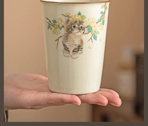 Macro detail of Ru ware ceramic cup with cat illustration and ice-crack glaze texture