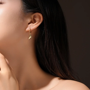 Detailed view of gold geometric pendant earrings with micro-inlaid sparkling zircon