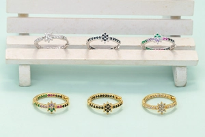 Detail of star-shaped hoop earrings featuring colorful zircon stones in gold and silver plating