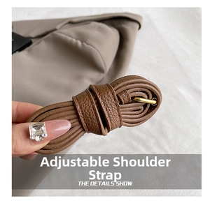 Detail of adjustable brown leather shoulder strap with litchi texture and gold buckle