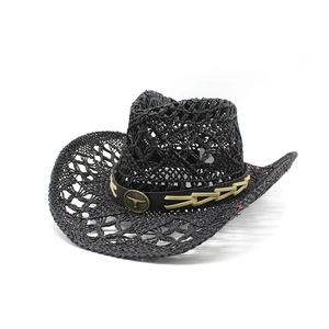 Dettaglio cappello cowboy nero con emblema testa di toro vintage su cinturino in pelle