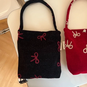 Gros plan du sac à main en tricot avec nœuds brodés et étiquette tissée sur le côté